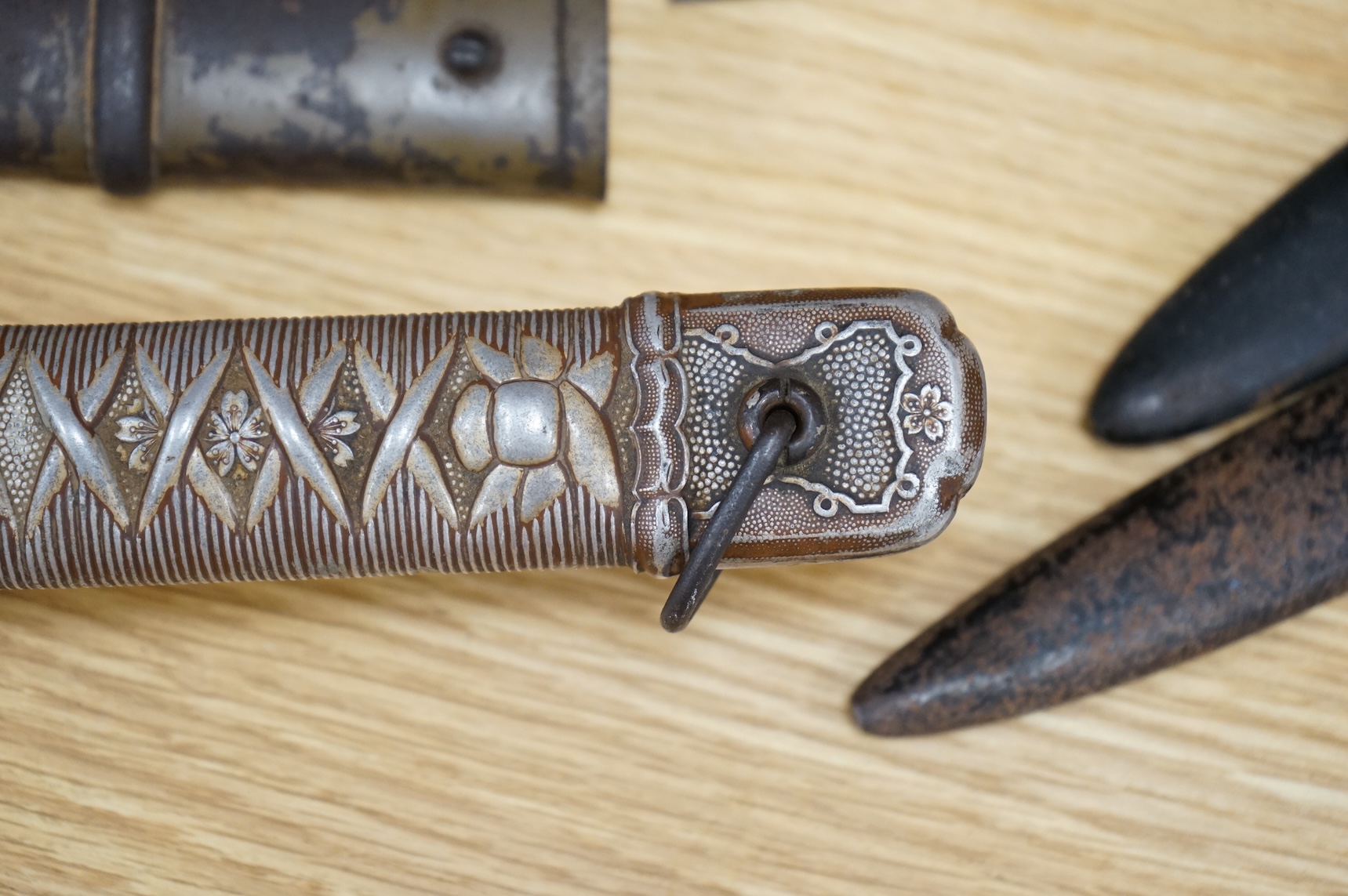 A Japanese World War II NCO‘s sword katana, regulation blade with fuller, stamped 33271, regulation aluminium hilt, brass guard, the spring catch still retains, in an iron scabbard